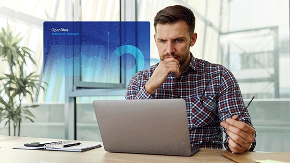 Man using a desktop in office with a graphic of Enterprise Manager dashboard overlaid on the background